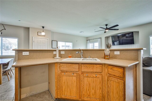 4833 Straight Flush Dr Unit 103, Las Vegas, NV 89122 - kitchen with a sink, a ceiling fan, light countertops, open floor plan, and tasteful backsplash