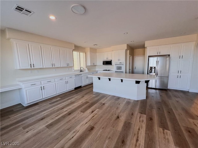 8616 Willow Cabin St, Las Vegas, NV 89131 - kitchen featuring stainless steel fridge with ice dispenser, white dishwasher, white cabinets, light countertops, and recessed lighting