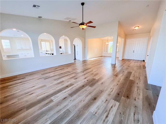 8616 Willow Cabin St, Las Vegas, NV 89131 - unfurnished living room featuring ceiling fan, light wood-style floors, and arched walkways