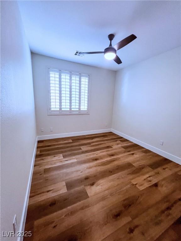 8616 Willow Cabin St, Las Vegas, NV 89131 - spare room with wood finished floors, a ceiling fan, and baseboards