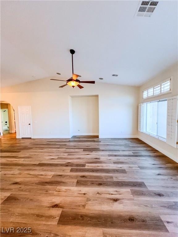 8616 Willow Cabin St, Las Vegas, NV 89131 - unfurnished living room with wood finished floors, arched walkways, a ceiling fan, baseboards, and vaulted ceiling