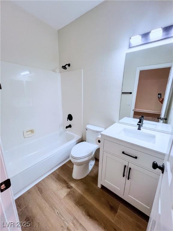 8616 Willow Cabin St, Las Vegas, NV 89131 - bathroom featuring vanity, wood finished floors, toilet, and shower / washtub combination
