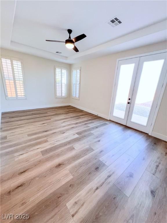8616 Willow Cabin St, Las Vegas, NV 89131 - empty room featuring a raised ceiling, french doors, light wood finished floors, ceiling fan, and baseboards