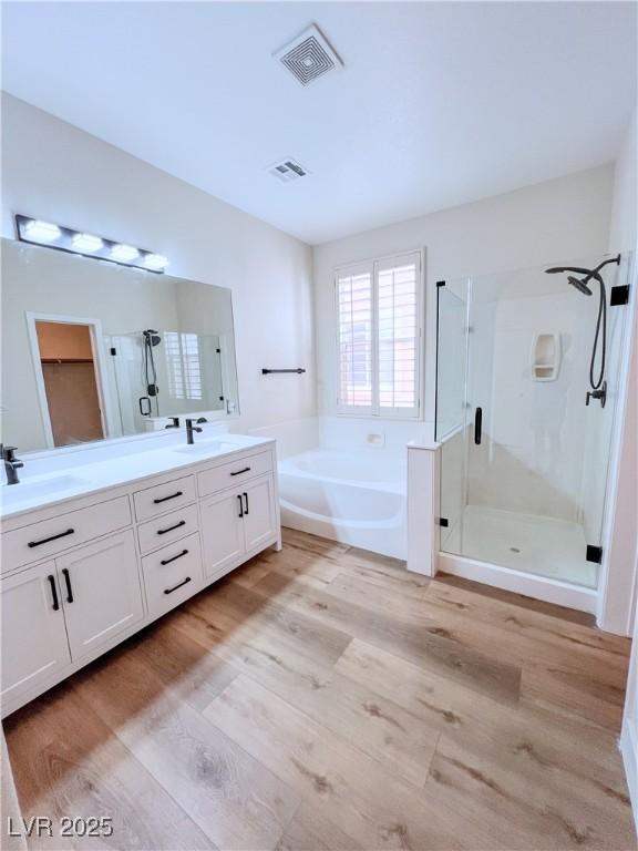 8616 Willow Cabin St, Las Vegas, NV 89131 - bathroom with a shower stall, a bath, double vanity, and wood finished floors