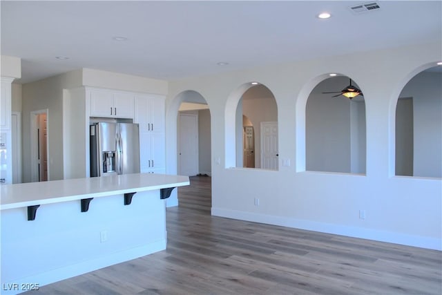 8616 Willow Cabin St, Las Vegas, NV 89131 - kitchen featuring stainless steel refrigerator with ice dispenser, a breakfast bar area, light countertops, light wood-type flooring, and recessed lighting