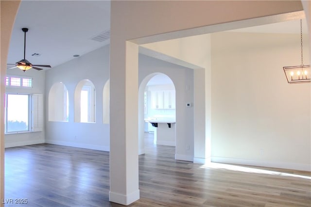 8616 Willow Cabin St, Las Vegas, NV 89131 - spare room featuring wood finished floors, ceiling fan, arched walkways, and a chandelier