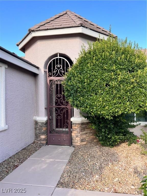 8616 Willow Cabin St, Las Vegas, NV 89131 - entrance to property featuring stucco siding, a tiled roof, and a gate