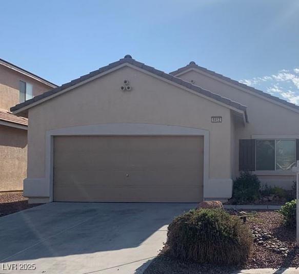 6412 Starling Mesa St, North Las Vegas, NV 89086 - view of front facade with stucco siding, a garage, and driveway