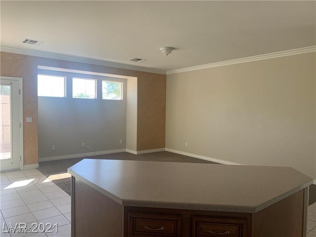 6412 Starling Mesa St, North Las Vegas, NV 89086 - kitchen featuring ornamental molding, a kitchen island, baseboards, light tile patterned floors, and light countertops