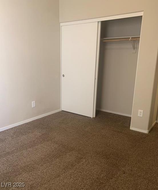 6412 Starling Mesa St, North Las Vegas, NV 89086 - unfurnished bedroom featuring a closet, baseboards, and dark colored carpet