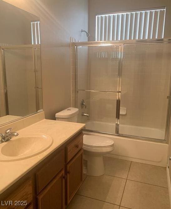 6412 Starling Mesa St, North Las Vegas, NV 89086 - bathroom featuring vanity, toilet, tile patterned flooring, and combined bath / shower with glass door