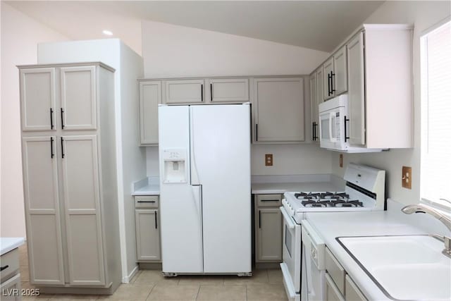 5112 Foggia Ave, Las Vegas, NV 89130 - kitchen with white appliances, a sink, light countertops, light tile patterned floors, and vaulted ceiling
