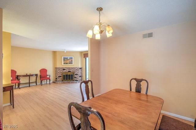 5713 Whiteridge Ave, Las Vegas, NV 89107 - dining area featuring a chandelier, baseboards, a fireplace, and light wood-type flooring
