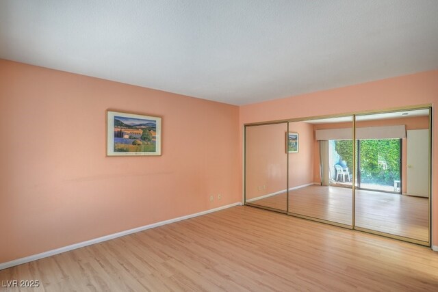 5713 Whiteridge Ave, Las Vegas, NV 89107 - unfurnished bedroom with light wood-style flooring, baseboards, access to outside, and a closet