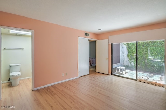 5713 Whiteridge Ave, Las Vegas, NV 89107 - unfurnished bedroom featuring access to exterior, light wood-style floors, baseboards, and ensuite bath