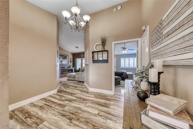 7670 Descanso Ln, Las Vegas, NV 89123 - foyer featuring a chandelier, lofted ceiling, wood finished floors, a warm lit fireplace, and ceiling fan