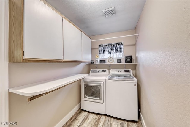 7670 Descanso Ln, Las Vegas, NV 89123 - laundry room with cabinet space, washing machine and dryer, and light wood finished floors