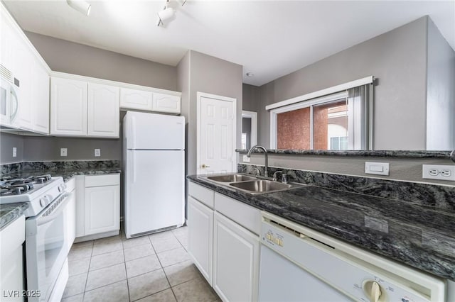 9303 Gilcrease Ave Unit 1013, Las Vegas, NV 89149 - kitchen featuring white appliances, a sink, white cabinetry, light tile patterned flooring, and dark stone counters
