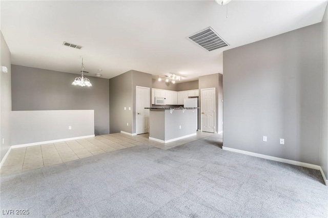 9303 Gilcrease Ave Unit 1013, Las Vegas, NV 89149 - unfurnished living room featuring light carpet, a chandelier, and baseboards