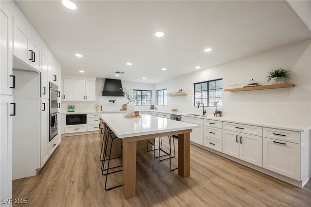 1917 N Moapa Valley Blvd, Logandale, NV 89021 - kitchen with open shelves, a breakfast bar area, black microwave, stainless steel double oven, and custom exhaust hood