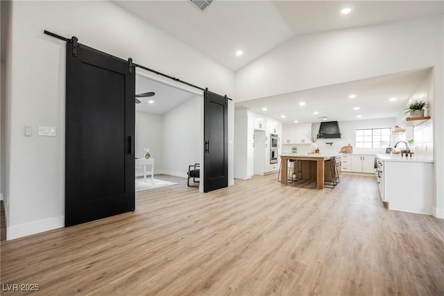 1917 N Moapa Valley Blvd, Logandale, NV 89021 - living area featuring a barn door, light wood-style flooring, lofted ceiling, baseboards, and recessed lighting