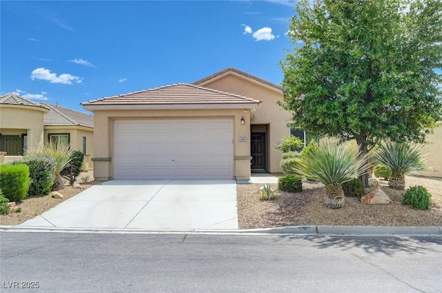 2445 Sturrock Dr, Henderson, NV 89044 - view of front of house with an attached garage, stucco siding, driveway, and a tile roof