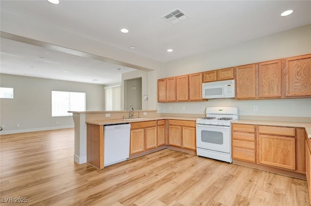 2445 Sturrock Dr, Henderson, NV 89044 - kitchen with white appliances, a sink, a peninsula, light wood-type flooring, and light countertops