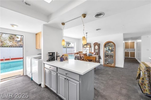 1589 Silver Mesa Way, Las Vegas, NV 89169 - kitchen with independent washer and dryer, a peninsula, light countertops, and dark tile patterned flooring