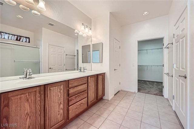 7465 Widewing Dr, North Las Vegas, NV 89084 - bathroom with tile patterned flooring, double vanity, baseboards, recessed lighting, and a shower with shower door