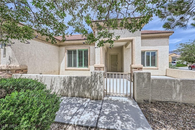 7465 Widewing Dr, North Las Vegas, NV 89084 - view of front facade featuring stucco siding, a fenced front yard, and a gate