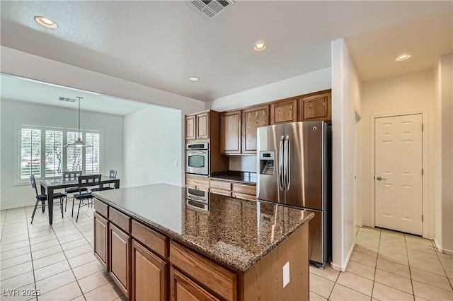 7465 Widewing Dr, North Las Vegas, NV 89084 - kitchen with stainless steel appliances, light tile patterned flooring, a kitchen island, recessed lighting, and hanging light fixtures