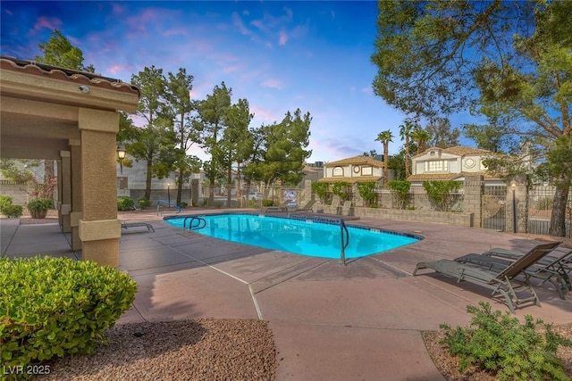 3481 Creek River Dr, Las Vegas, NV 89129 - pool at dusk with a community pool and a patio area