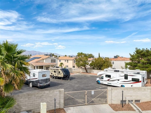 3481 Creek River Dr, Las Vegas, NV 89129 - uncovered parking lot featuring a fenced front yard, a gate, a residential view, and a mountain view