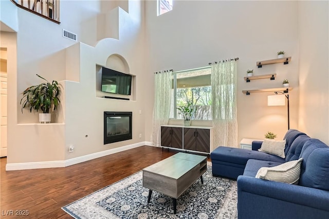 9192 Moose Country Pl, Las Vegas, NV 89178 - living room featuring wood finished floors, plenty of natural light, baseboards, and a towering ceiling