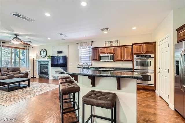 9192 Moose Country Pl, Las Vegas, NV 89178 - kitchen with stainless steel appliances, a kitchen breakfast bar, healthy amount of natural light, wood finished floors, and recessed lighting