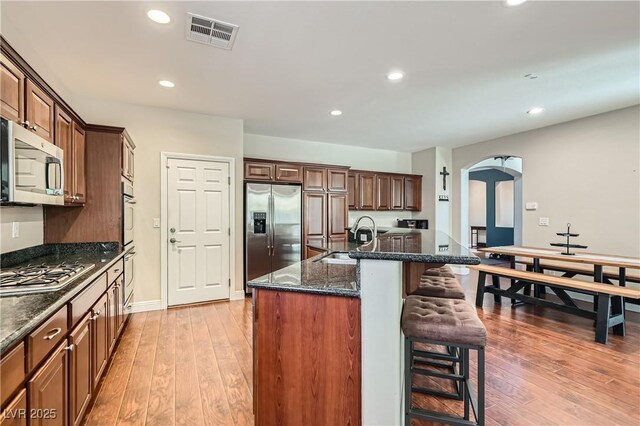 9192 Moose Country Pl, Las Vegas, NV 89178 - kitchen featuring stainless steel appliances, a sink, arched walkways, a breakfast bar, and recessed lighting