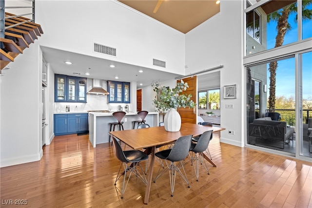 11441 Allerton Park Dr Unit 212, Las Vegas, NV 89135 - dining room featuring a towering ceiling, baseboards, light wood-style flooring, recessed lighting, and stairs