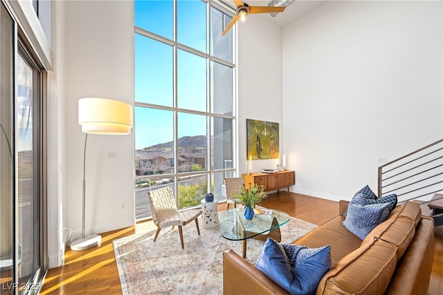 11441 Allerton Park Dr Unit 212, Las Vegas, NV 89135 - living room featuring a high ceiling, wood finished floors, a mountain view, and baseboards