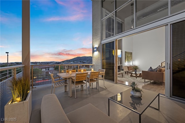 11441 Allerton Park Dr Unit 212, Las Vegas, NV 89135 - balcony at dusk with outdoor dining area and a mountain view