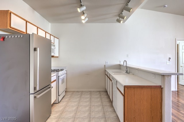 4960 Harrison Dr Unit 214, Las Vegas, NV 89120 - kitchen featuring white appliances, a sink, track lighting, a peninsula, and light countertops