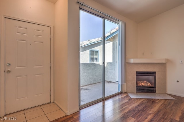 4960 Harrison Dr Unit 214, Las Vegas, NV 89120 - unfurnished living room with wood finished floors, a tile fireplace, and baseboards