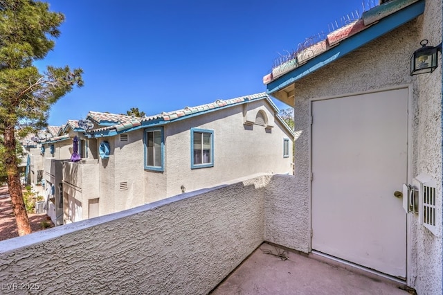 4960 Harrison Dr Unit 214, Las Vegas, NV 89120 - view of side of home with a balcony, stucco siding, and a tile roof