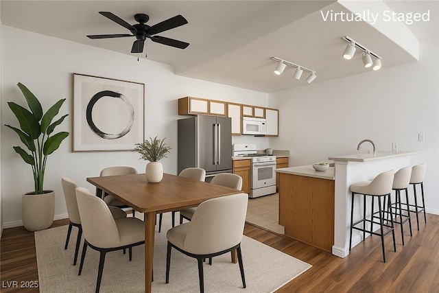 4960 Harrison Dr Unit 214, Las Vegas, NV 89120 - dining space featuring track lighting, wood finished floors, a ceiling fan, and baseboards