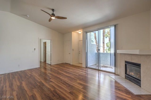 4960 Harrison Dr Unit 214, Las Vegas, NV 89120 - unfurnished living room featuring vaulted ceiling, wood finished floors, ceiling fan, a fireplace, and baseboards