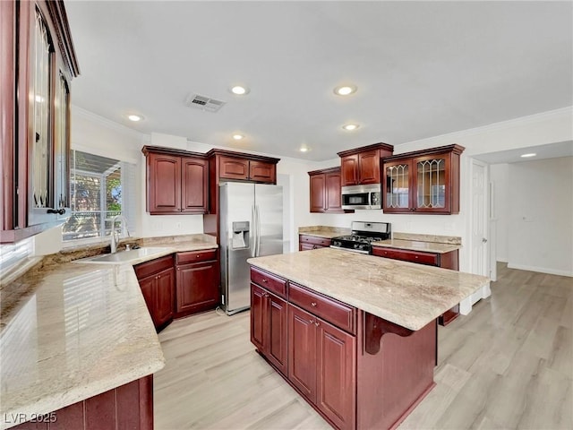 8632 Skyward Ct, Las Vegas, NV 89145 - kitchen featuring appliances with stainless steel finishes, reddish brown cabinets, crown molding, a sink, and light wood-style flooring