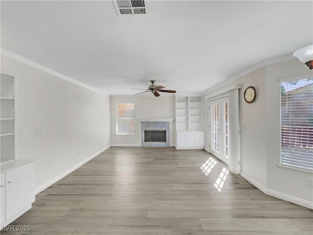 8632 Skyward Ct, Las Vegas, NV 89145 - unfurnished living room featuring ceiling fan, crown molding, healthy amount of natural light, french doors, and built in shelves