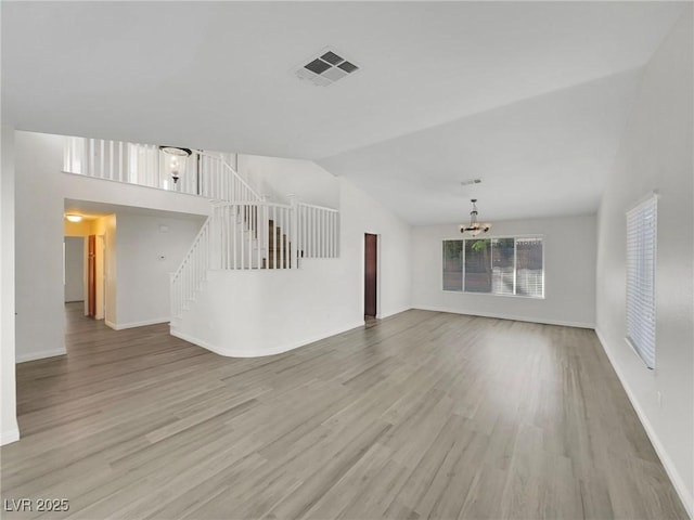 8632 Skyward Ct, Las Vegas, NV 89145 - unfurnished living room with a chandelier, stairway, wood finished floors, baseboards, and vaulted ceiling