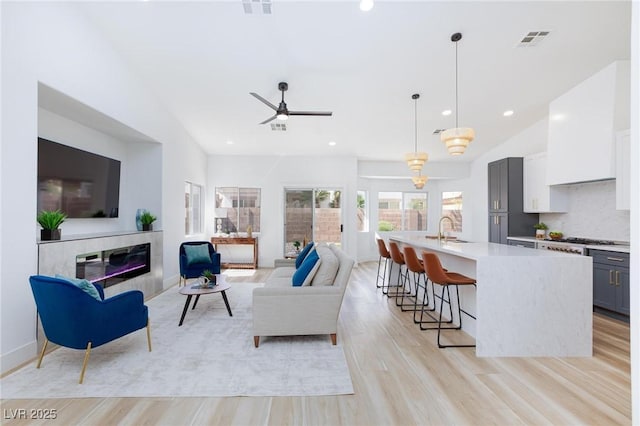 4176 Demoline Cir, Las Vegas, NV 89141 - living area with recessed lighting, a ceiling fan, a fireplace, light wood-style floors, and vaulted ceiling