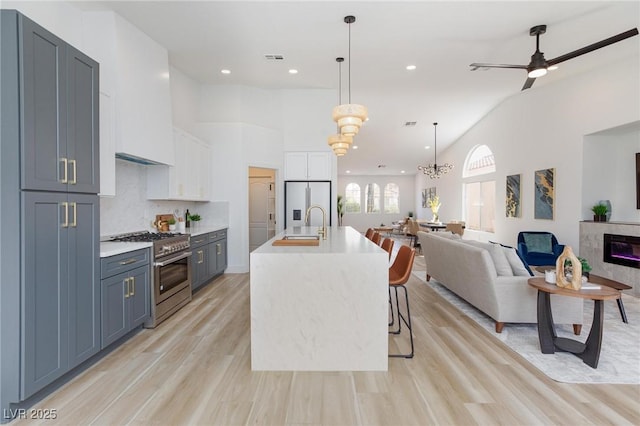 4176 Demoline Cir, Las Vegas, NV 89141 - kitchen featuring stainless steel appliances, open floor plan, light countertops, white cabinets, and light wood-style flooring
