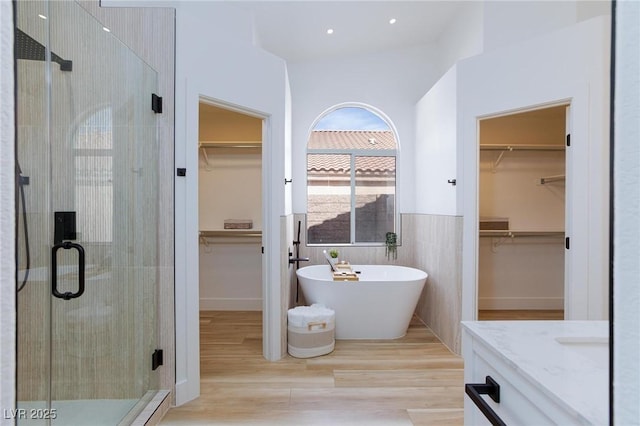 4176 Demoline Cir, Las Vegas, NV 89141 - bathroom with a stall shower, a walk in closet, a freestanding bath, vanity, and wood finished floors
